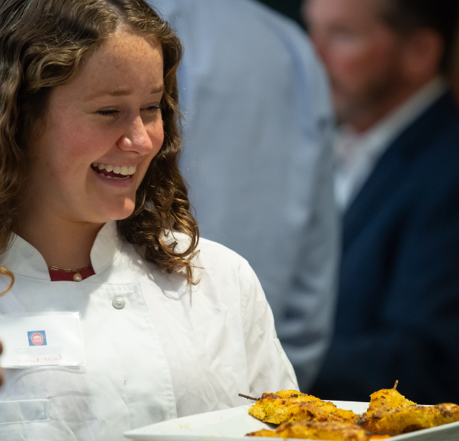 NHM student works at a school function as a server. 