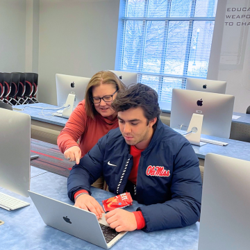 Students working together on a laptop. 