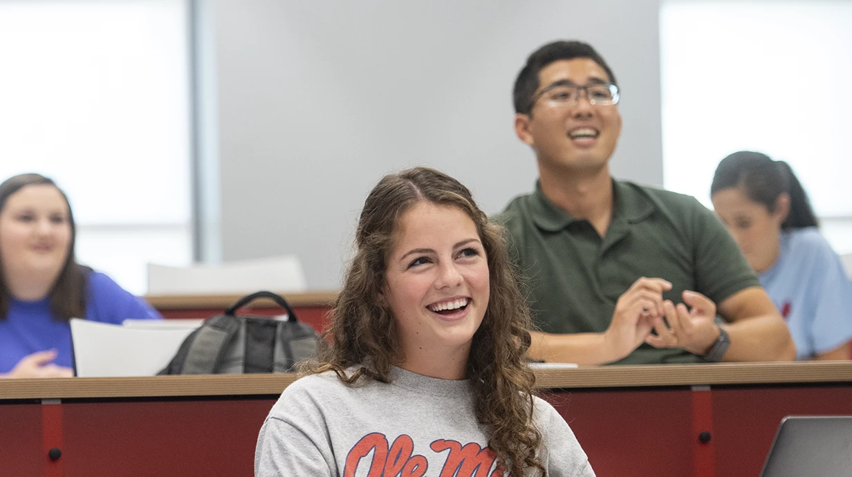 Two Master in Public Health students smile during class as they learn about public health.