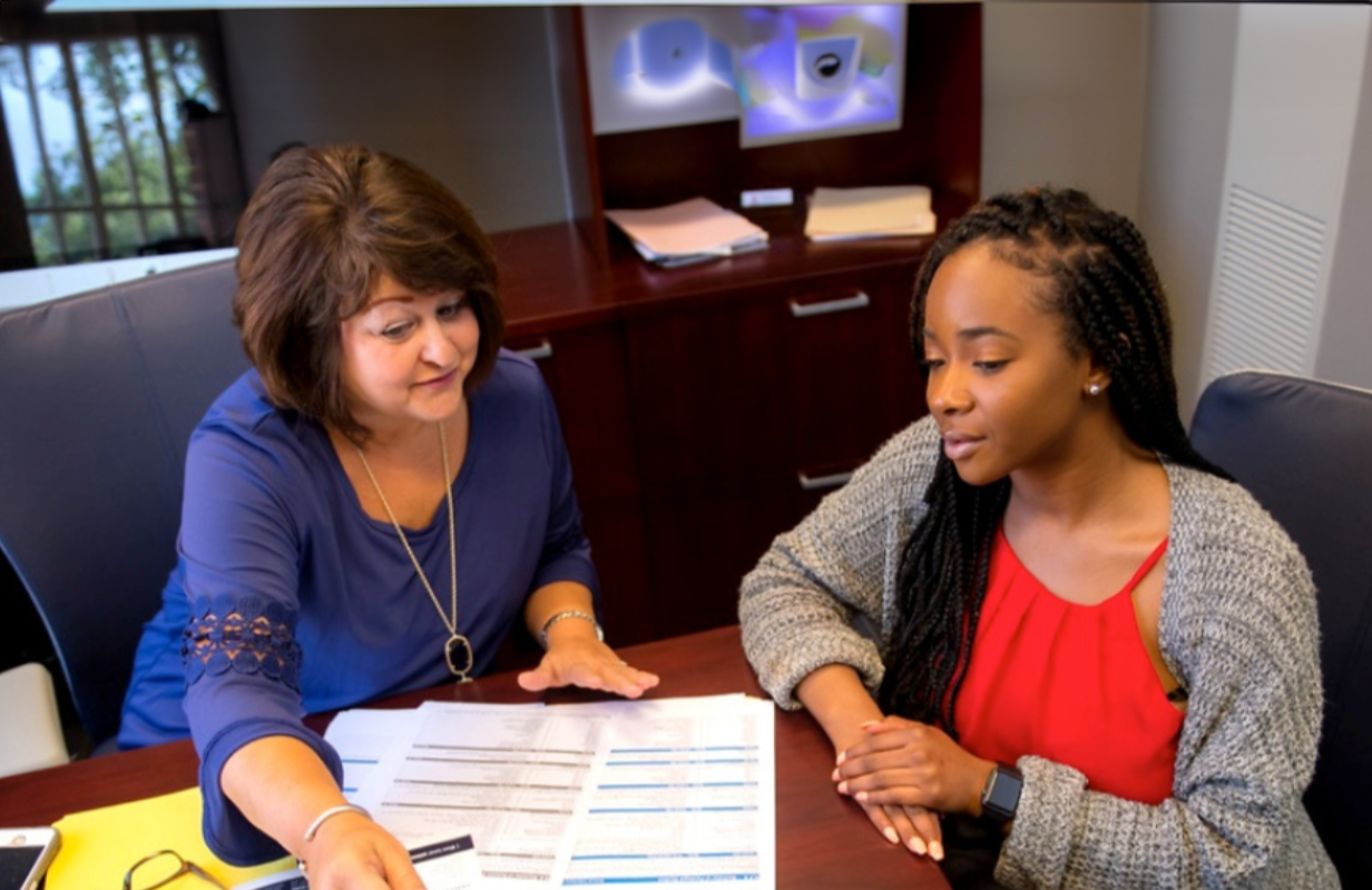 An academic adviser helping a girl pick classes